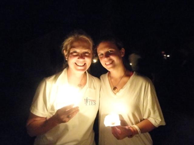 Mary Miles Loveless and her daughter Kate holding candles at the Camp Nakanawa Amazon Serenade in 2011, sharing a special moment illuminated by candlelight.